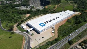 Foto aérea do Centro de Distribuição Apex Log Pitanga, localizado na Serra, Espírito Santo, próximo a uma rodovia e cercado por áreas verdes.