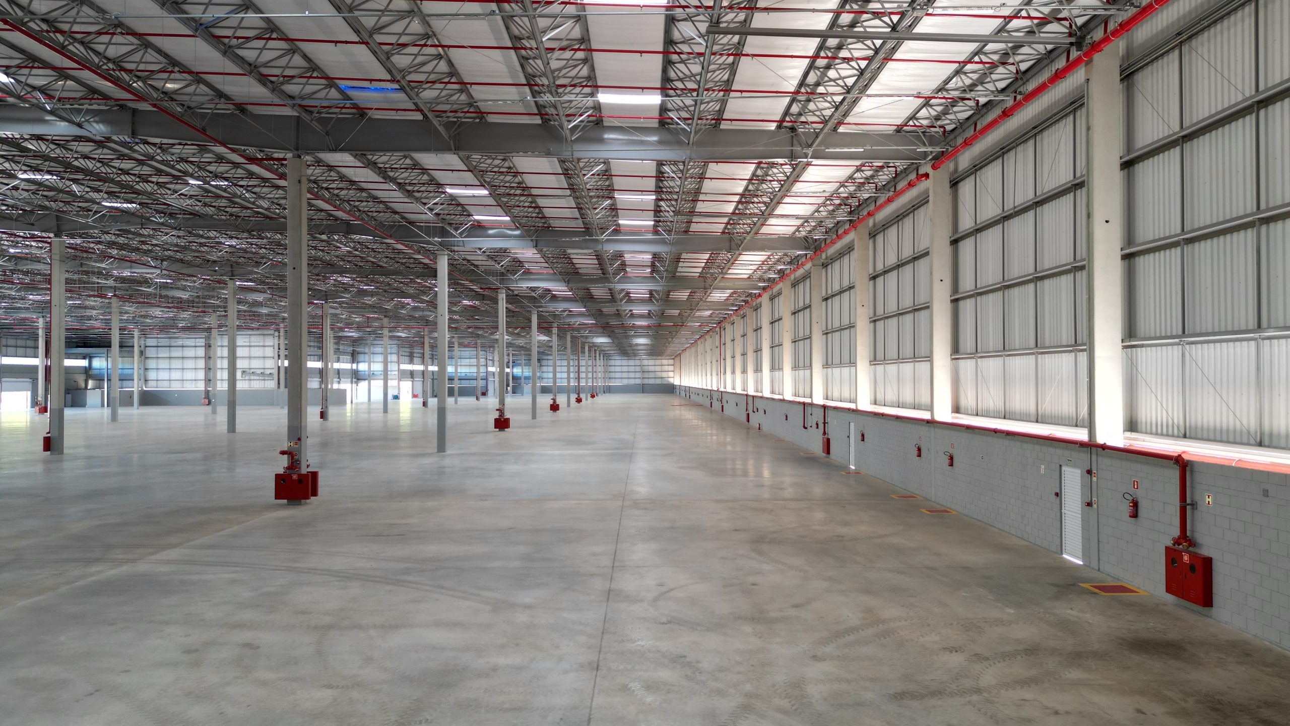 Interior do galpão logístico Apex Log Pitanga na Serra (ES), com piso de alta resistência e estrutura metálica modular.