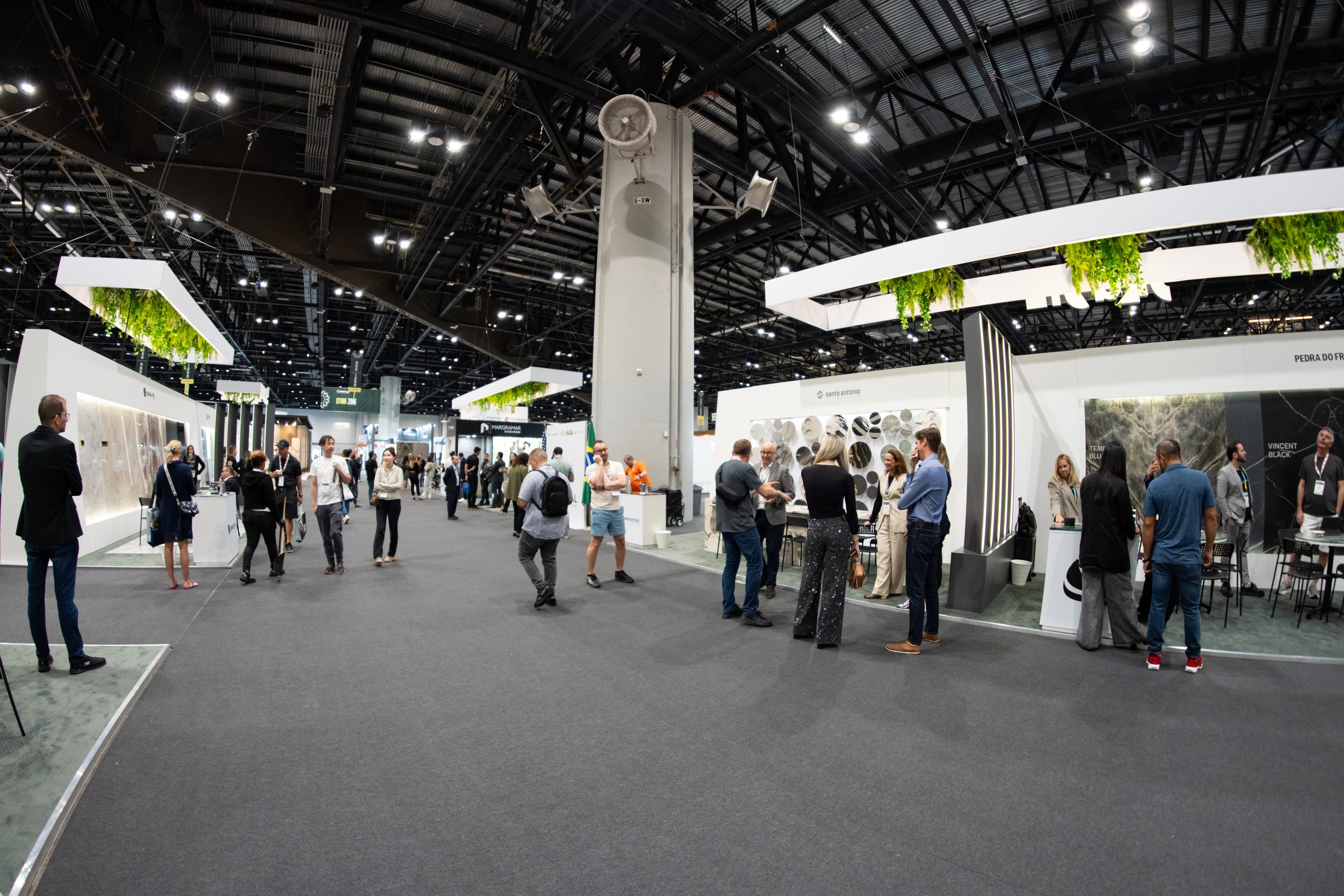 Pavilhão Brasileiro na Coverings 2025 em Orlando com expositores, amostras de mármore e granito e visitantes em networking